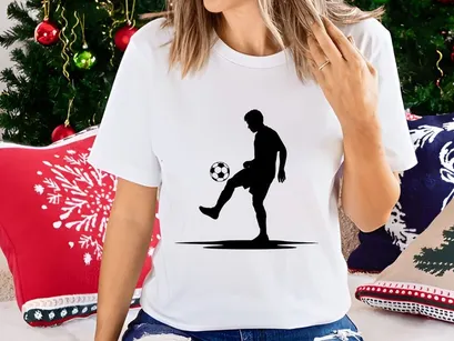 Silhouette of a soccer player kicking a ball in mid action