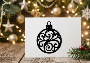 Black Christmas bauble silhouette with ornate floral filigree pattern on white background