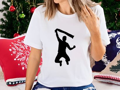 A silhouette of a person jumping and waving a scarf or cloth in the air energetically