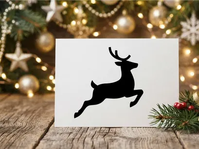 Black silhouette of a jumping reindeer isolated on a white background for Christmas design.