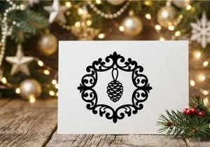 Black silhouette of a pine cone inside an ornate decorative circular frame for Christmas