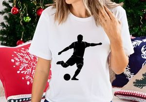 Silhouette of a soccer player kicking a ball in mid action