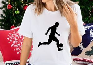 Silhouette of a soccer player kicking a ball in motion