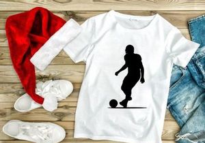 Silhouette of a soccer player kicking a ball in motion
